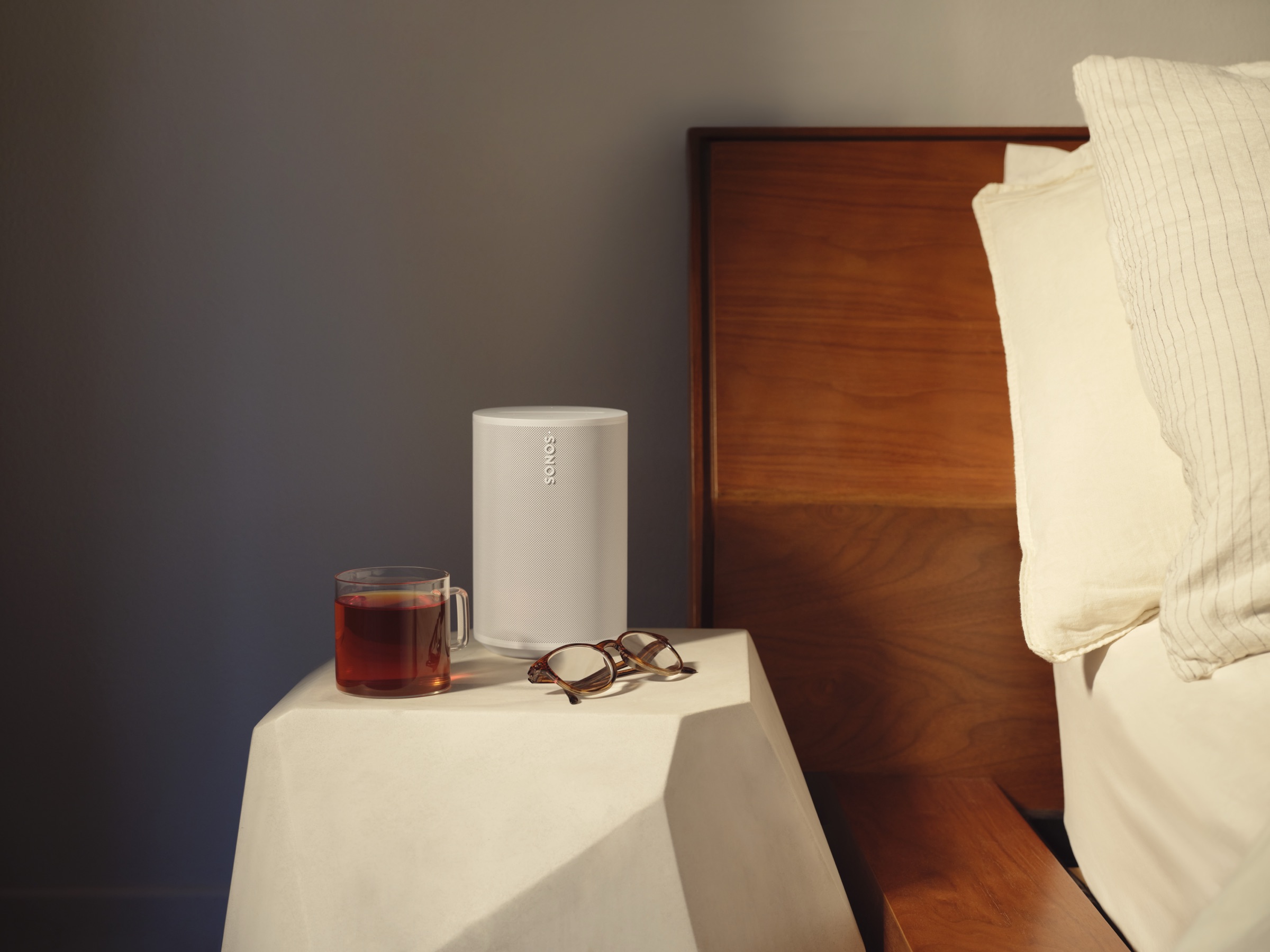 Sonos speaker on a bedside table in a compact room